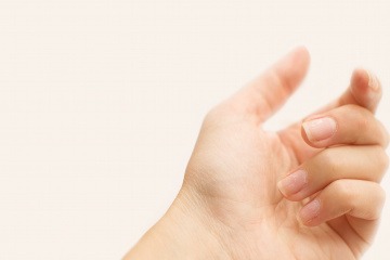 Finger mit einer eingerissenen Nagelhaut