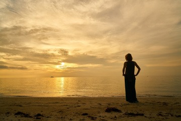 Eine Frau sieht auf das Meer hinaus