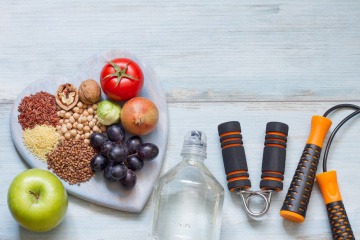 Obst für gesunde Ernährung liegt neben Sachen für Sport