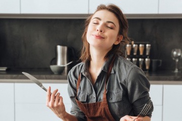 Frau genießt ihr Essen in der Küche