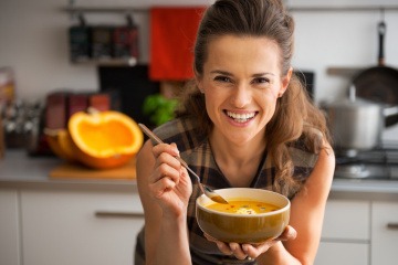 Frau isst Kürbiscremesuppe für Haarwachstum
