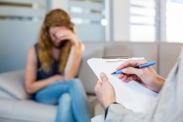 Eine Frau sitzt beim Arzt und macht einen Depression Test