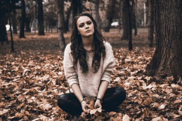 Eine Frau mit emotionalem Schmerz sitzt am Boden