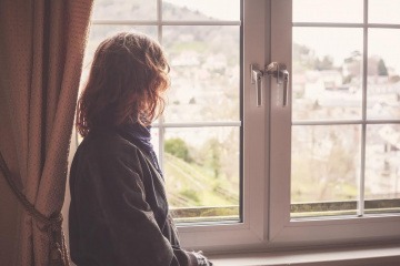 Eine Frau sieht aus dem Fenster