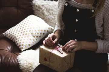 Eine Frau packt ein Geschenk aus