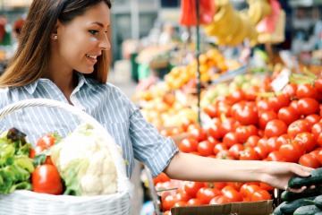 Frau kauft sich basische Lebensmittel am Markt