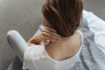 Frau mit Nackenschmerzen nach dem Schlafen