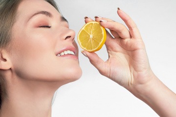 Frau hält eine Zitrone mit Fruchtsäure in der Hand