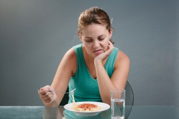 Eine Frau hat keinen Appetit und hat offensichtlich Appetitzügler genommen