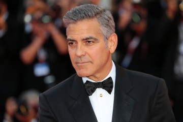 George Clooney hat einen Seitenscheitel und zurückgekämmtes Haar