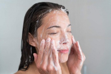 Eine Frau wäscht ihr Gesicht mit Seife
