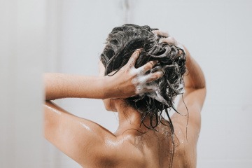 Frau beim Haarewaschen mit Haarpeeling