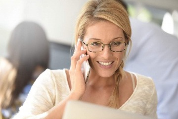 Eine Frau telefoniert mit ihrem Handy und lächelt dabei. Sie macht sich wohl keine Gedanken darüber, ob man Handystrahlung abschirmen sollte.