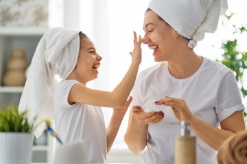 Frau und Mädchen bauen mit Kosmetik ihr Hautmikrobiom auf
