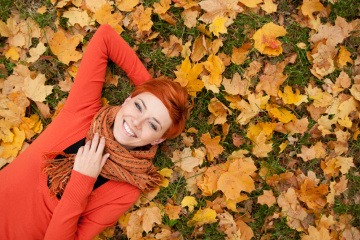 Frau mit gutem Immunsystem liegt auf einer herbstlichen Wiese