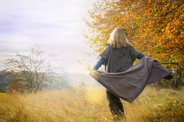 Frau in Herbstlandschaft von hinten