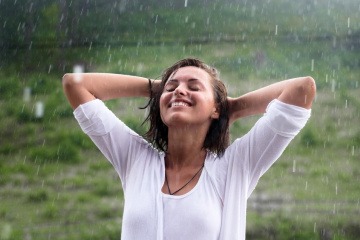 Frau steht im Regen 