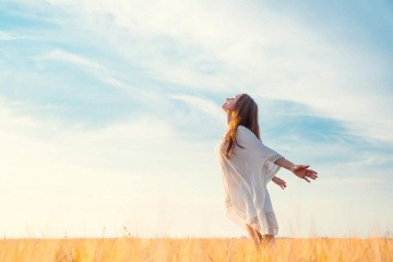 Diese Frau, die mit ausgebreiteten Armen am Strand steht und der Sonne entgegenblickt, hat ihre innere Klarheit offensichtlich bereits erlangt. 