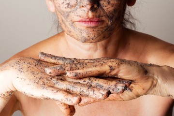 Eine Frau hält Kaffee-Peeling in der Hand