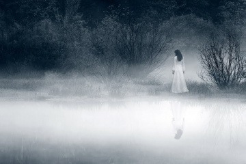Wer keine Gefühle mehr hat, fühlt sich wie diese Frau an einem nebligen See am Abend.