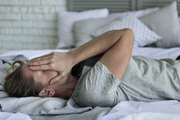 Eine Frau hat keine Hoffnung mehr und liegt am Bett