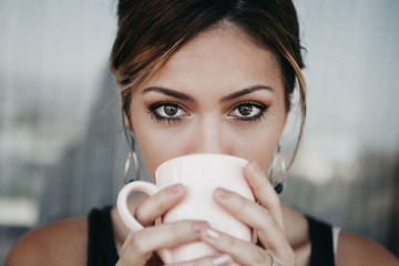 Eine Frau hat eine Tasse mit Kollagen zum Trinken