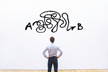 Warum sind Männer so kompliziert? Ein Mann steht vor einer Wand, auf die ein verwirrendes Muster gedruckt ist.