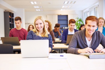 Ein Mann und eine Frau sitzen bei einem Fernlehrgang für Fitnesstrainer Ausbildung