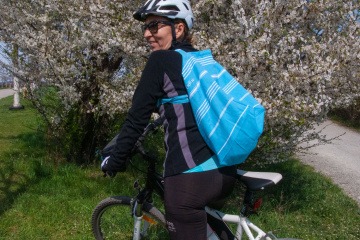 Eine Frau fährt mit einer trendigen Tasche Fahrrad