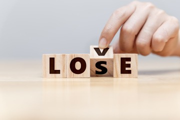 Die Buchstaben auf vier Holzblöcken ergeben das Wort Love. Dreht man jedoch den V-Holzblock, wird aus Love Lose. 