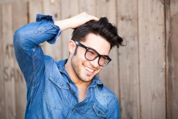 Junger Mann mit schönen Haaren und Brille.