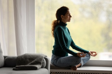 Eine Frau macht Meditation gegen Kopfschmerzen