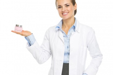 Eine Medizinerin hält Kosmetikprodukte in der Hand