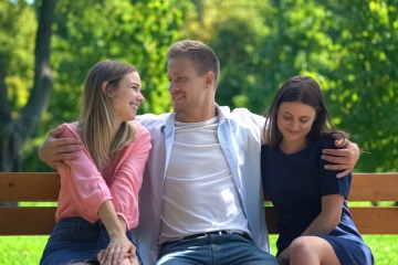 Kann man mehrere Menschen lieben, wie der Mann in diesem Bild, der zwei Frauen umarmt?