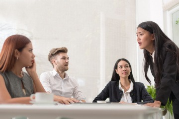 Eine Frau vertritt vor anderen ihre Meinung oder ihren Standpunkt