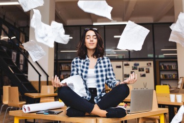 Meditierenden Frau auf einem Büroschreibtisch