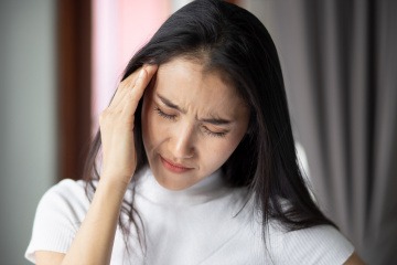 Frau mit einseitigen Kopfschmerzen oder Migräne