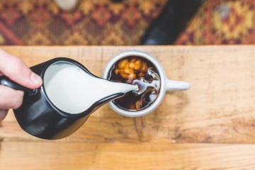 Aus einem Milchkännchen rinnt Milch