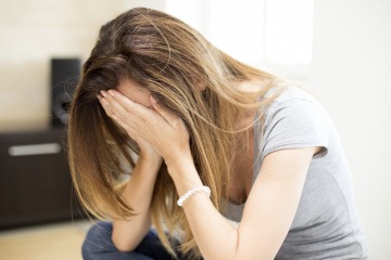 Eine Frau liegt müde beim Tisch