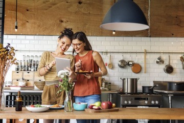 Nachhaltig zu kochen bedeutet, sich wie die Frau in diesem Bild an saisonalen und regionalen Lebensmitteln zu orientieren, die vor ihr auf dem Küchentresen liegen.