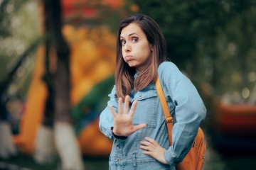 Frau auf der Straße will negative Menschen meiden und hat abwehrende Körperhaltung.