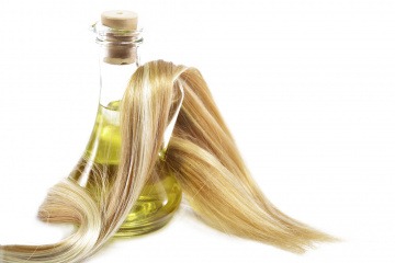 Haare sind um eine Flasche Olivenöl gelegt