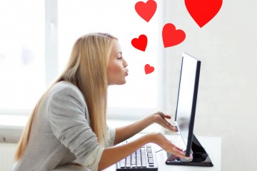 Kann man sich online verlieben, wie diese Frau, die Kussherzen in Richtung ihres Bildschirms schickt? 