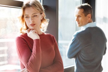 Eine Frau schaut verzweifelt, der Partner wirkt abweisend