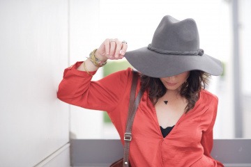 Eine Frau mit Hut hat keine Pickel im Ausschnitt