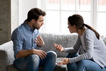 Streitendes junges Paar auf der Couch