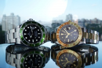 Zwei Uhren von Rolex liegen auf einer Fläche, eventuell als Geldanlage