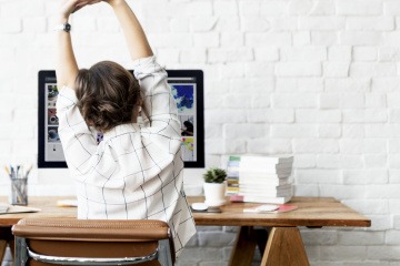 Frau fühlt sich an ihrem Bürotisch wohl