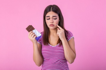 Frau mit Schokolade und Akne