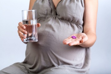 Eine schwangere Frau hat Medikamente in der Hand